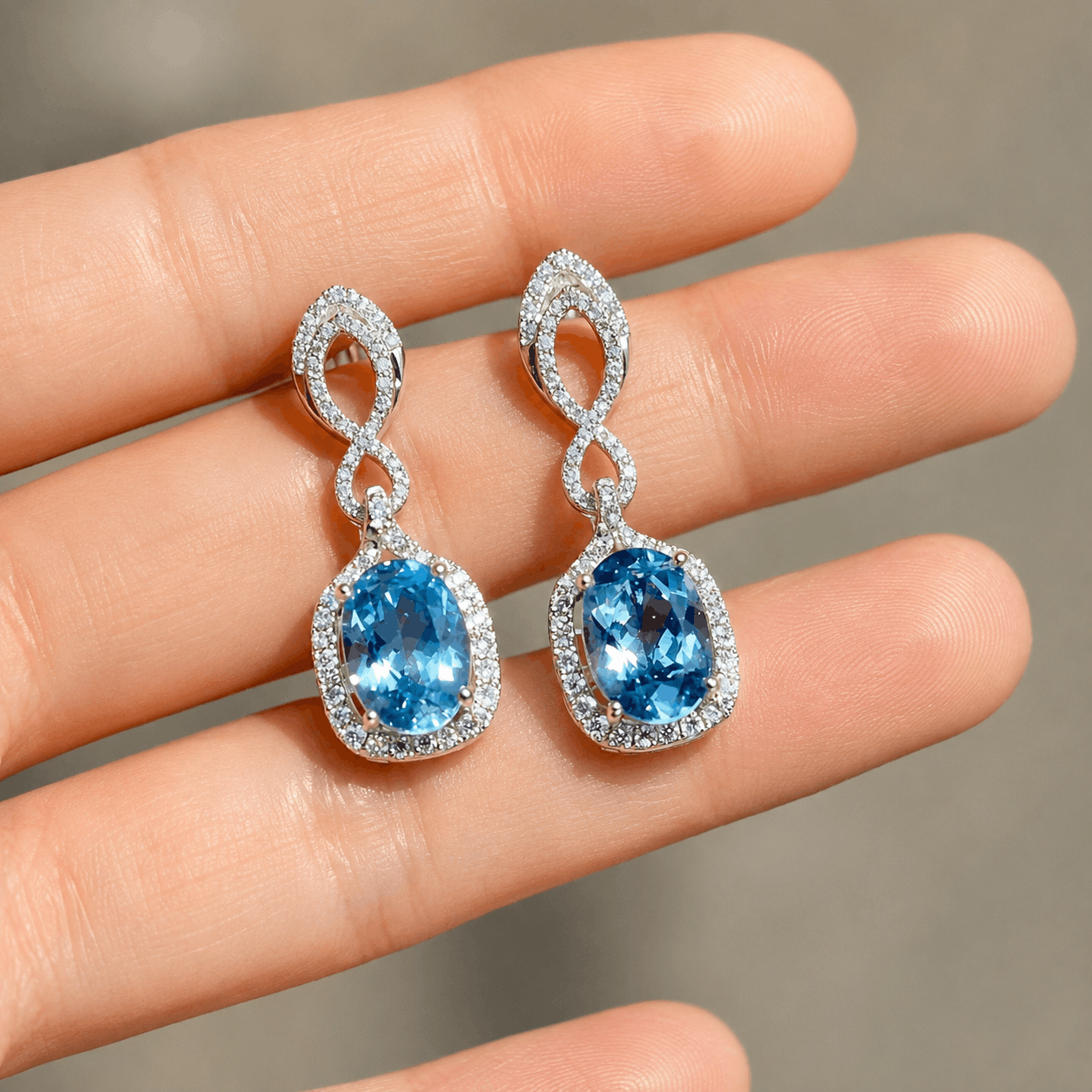 Oval aquamarine drop earrings with diamond halo and twisted white gold design
