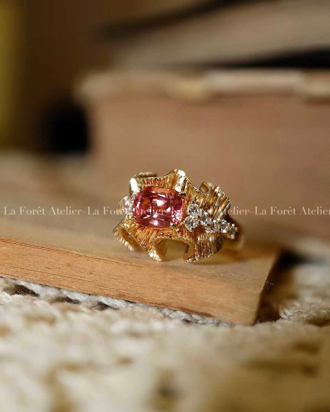 Ribbon-style ring with peach-pink Padparadscha sapphire
