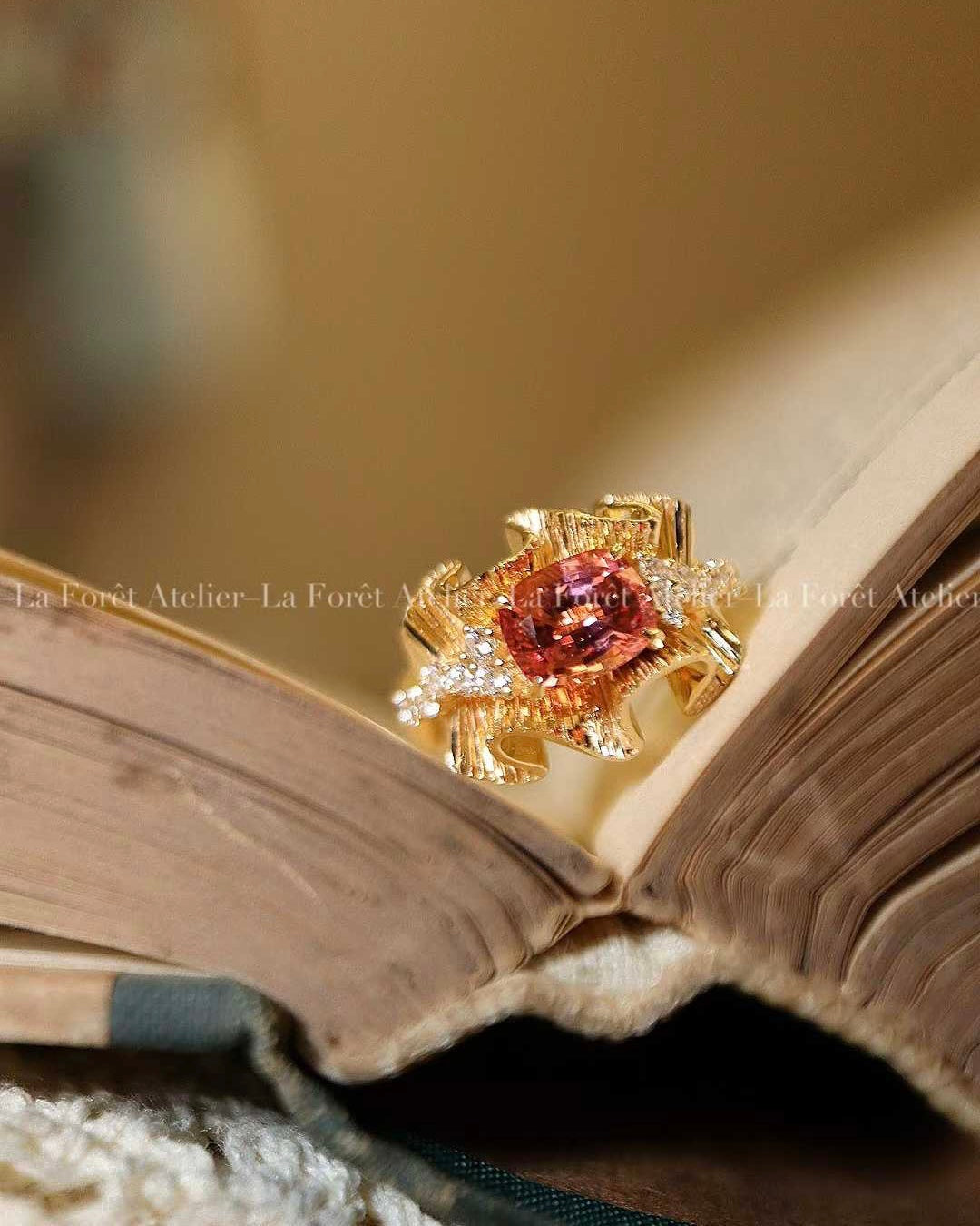Ribbon-style ring with peach-pink Padparadscha sapphire
