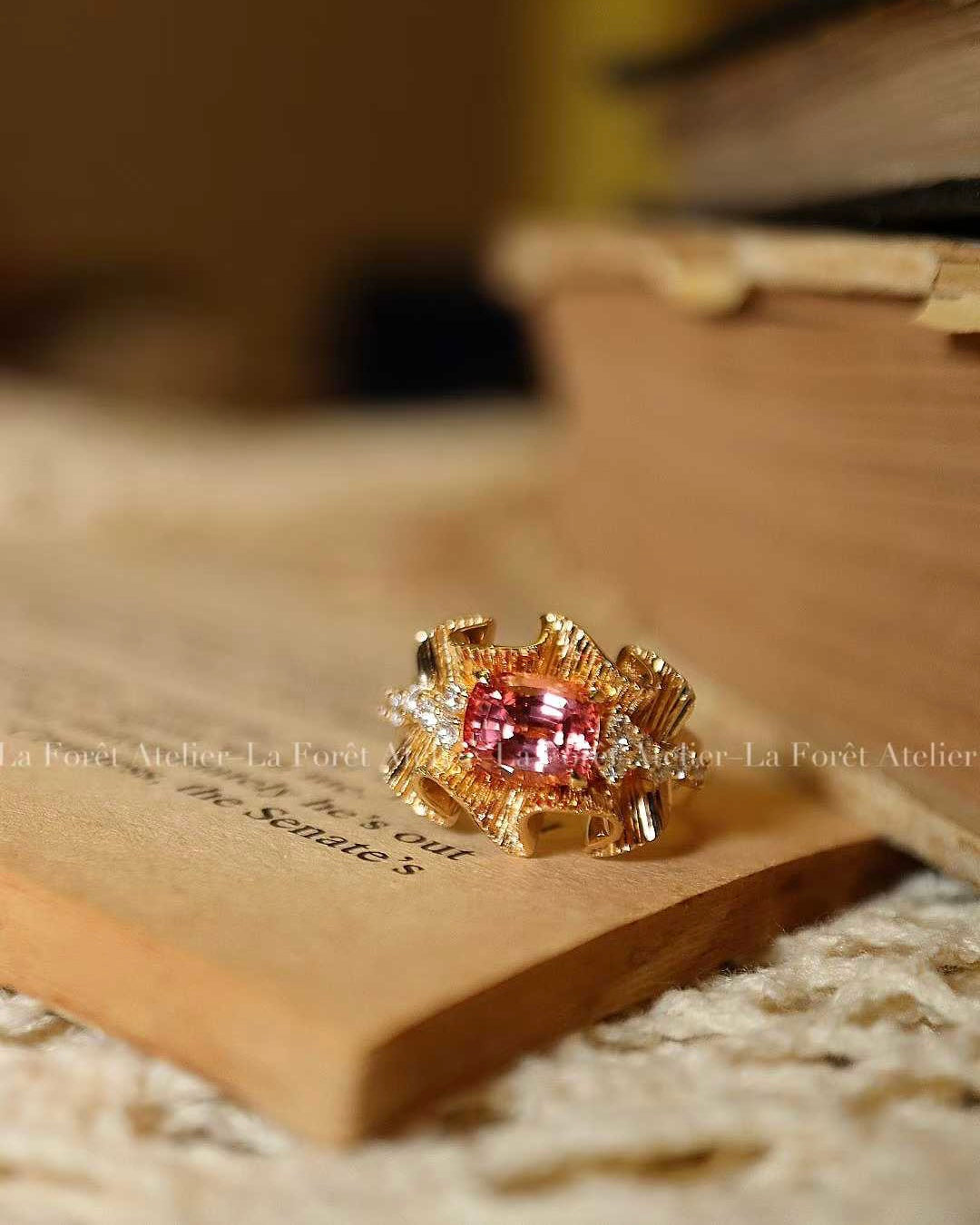 Ribbon-style ring with peach-pink Padparadscha sapphire
