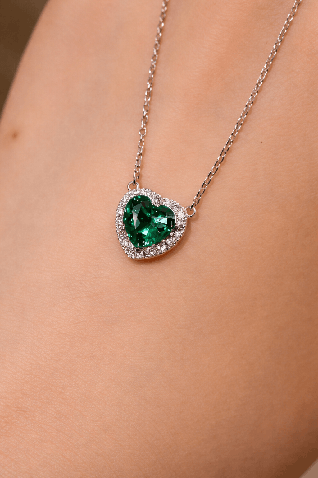 Heart-shaped 1ct lab-grown emerald necklace with diamond halo on silver chain

