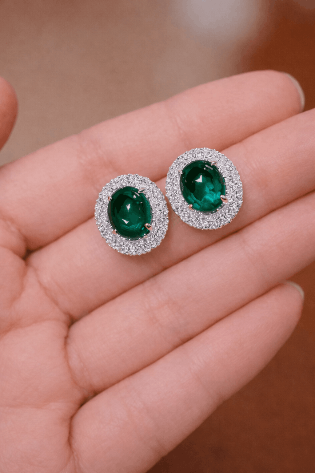 Pair of oval lab emerald stud earrings with double halo setting
