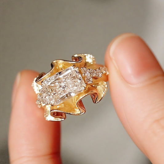 Radiant-cut diamond ring with sculptural wave gold band


