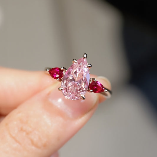 Pear-shaped pink diamond ring with ruby accents

