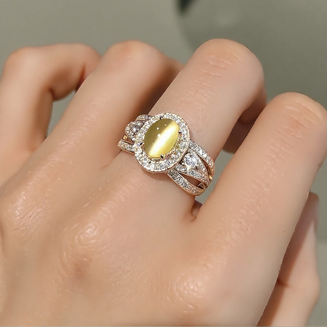 Gold ring with oval lab-grown chrysoberyl cat’s eye and diamond halo








