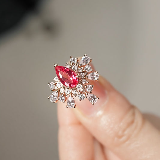 Zelara gold ring with 5x7mm pear-cut pink sapphire and starburst halo of lab-grown white stones








