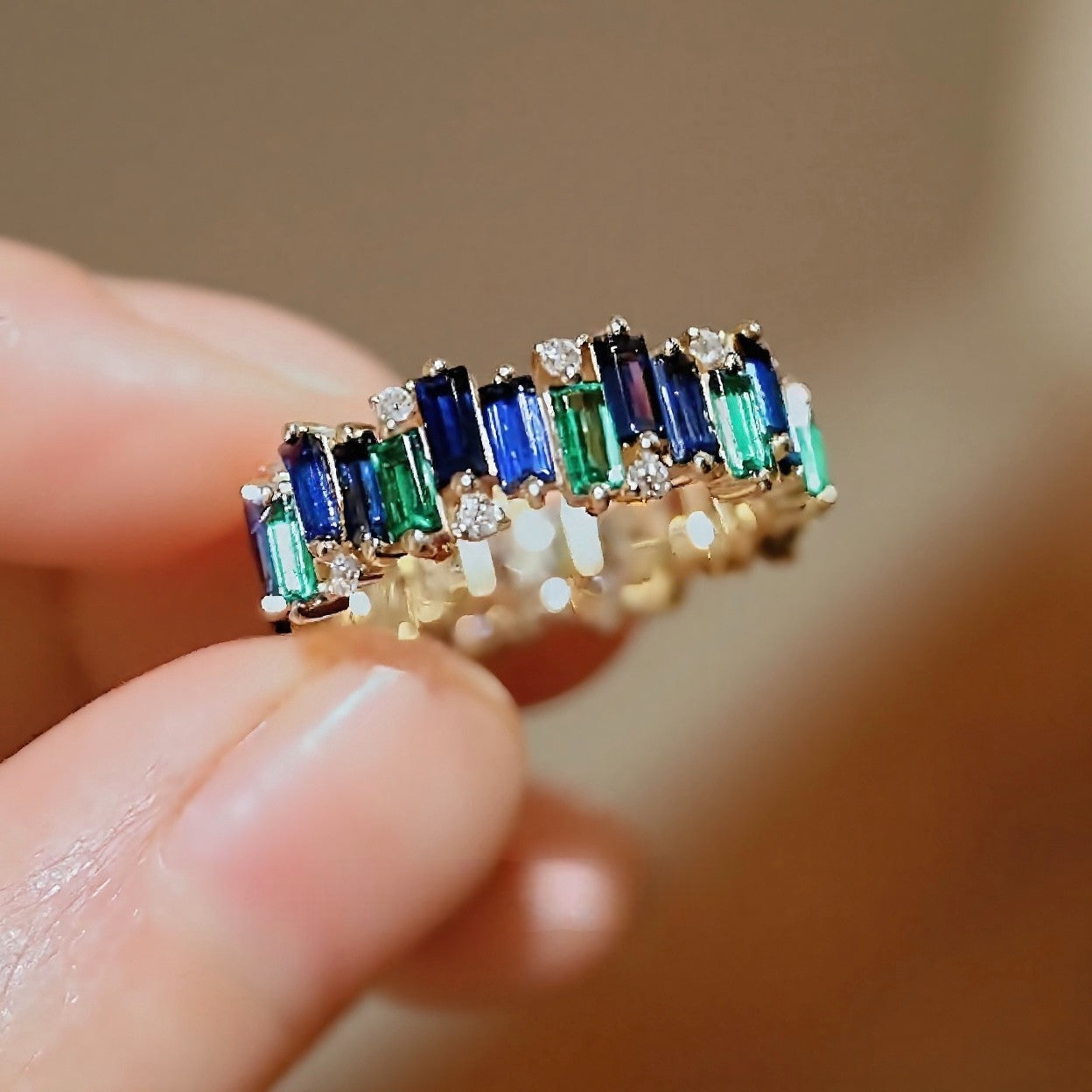 Sienna ring featuring emerald and sapphire baguettes in a full eternity band design








