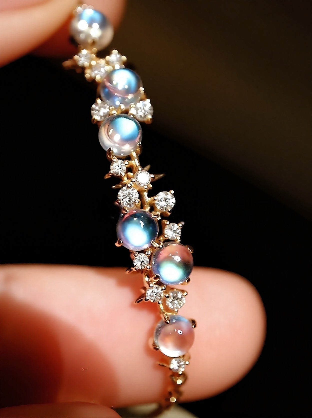 Helisse bracelet featuring glowing blue moonstones and diamond accents in gold setting