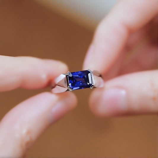 Modern bezel-set ring with 2ct emerald-cut lab-grown sapphire in silver band








