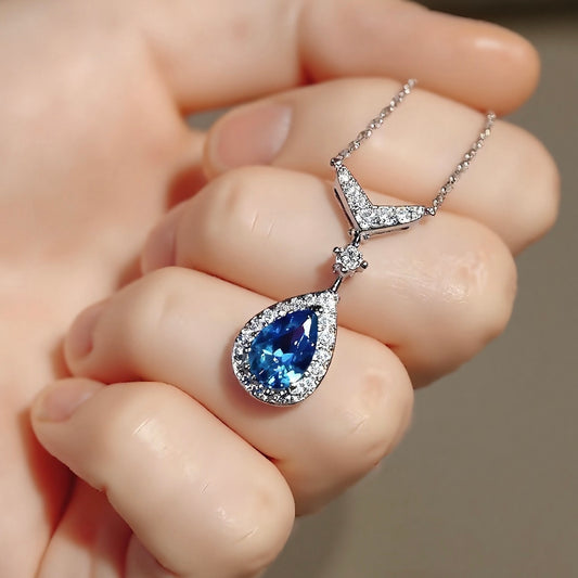 Teardrop aquamarine pendant in halo diamond setting with white gold chain








