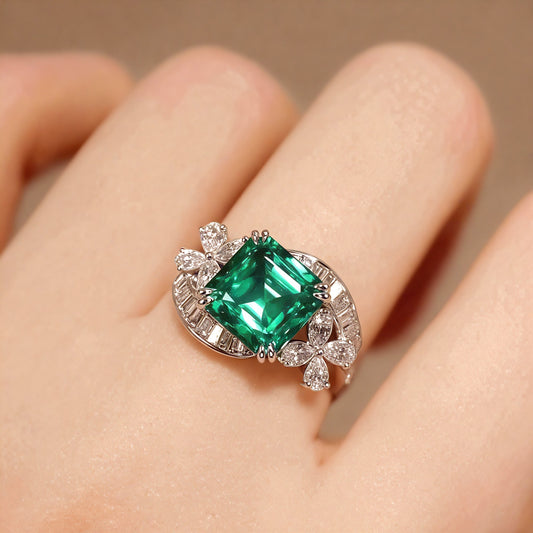 Emerald-cut green stone ring with floral diamond halo


