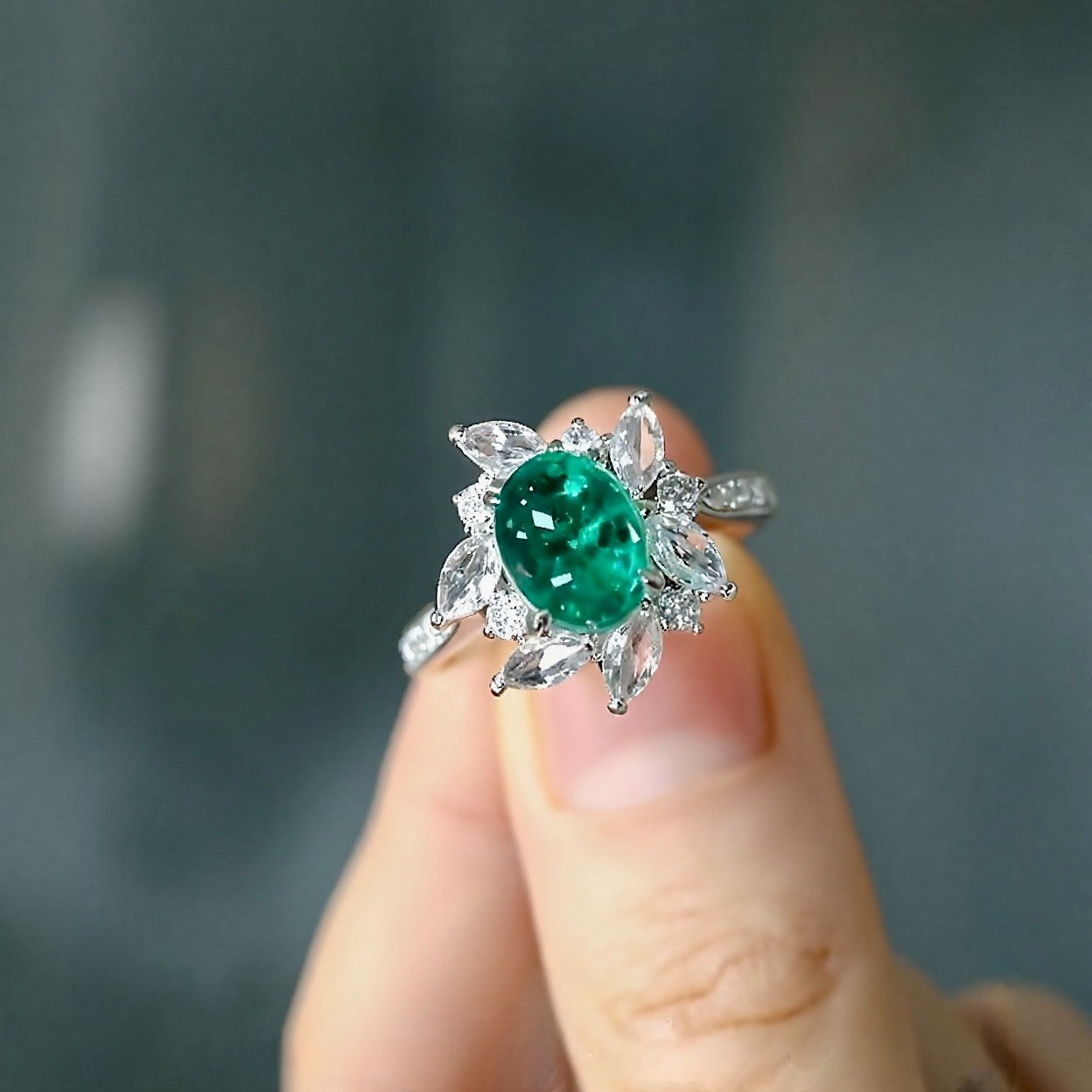 Floral halo ring with oval lab emerald and marquise diamonds








