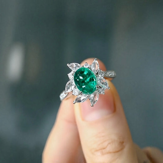 Floral halo ring with oval lab emerald and marquise diamonds








