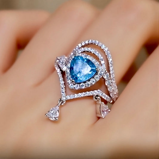 Trillion-cut apatite ring with halo setting and diamond-accented draped design








