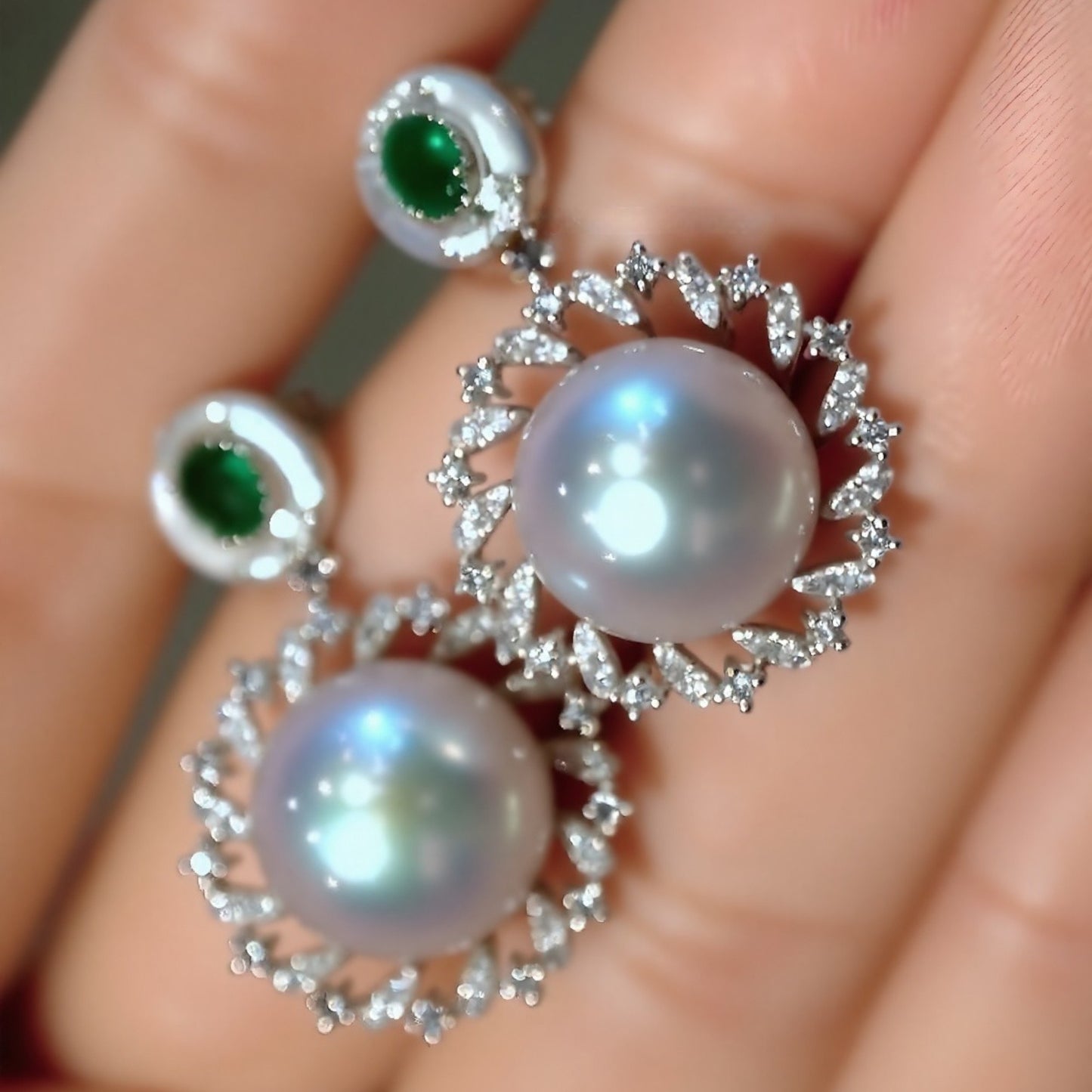 Close-up of Amaris pearl and emerald drop earrings with diamonds
