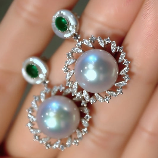 Close-up of Amaris pearl and emerald drop earrings with diamonds
