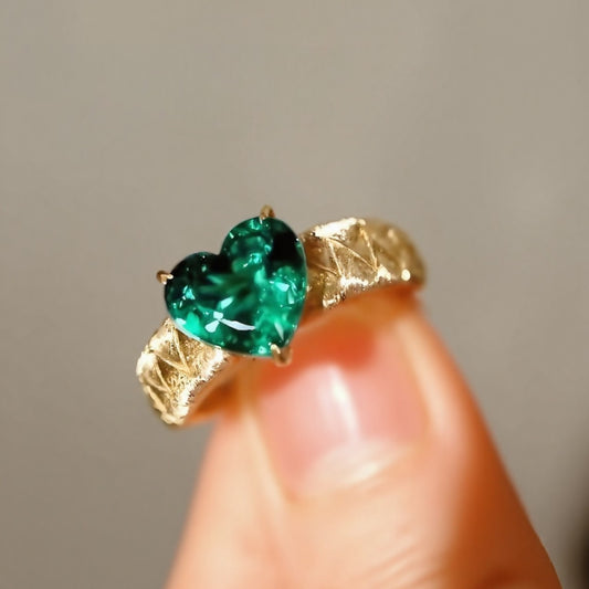 Heart-cut lab emerald ring with quilted gold band
