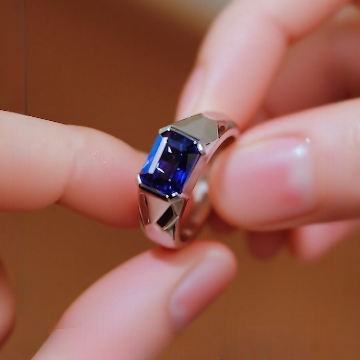 Modern bezel-set ring with 2ct emerald-cut lab-grown sapphire in silver band








