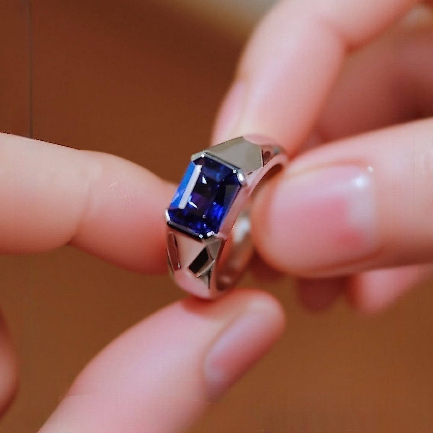 Modern bezel-set ring with 2ct emerald-cut lab-grown sapphire in silver band








