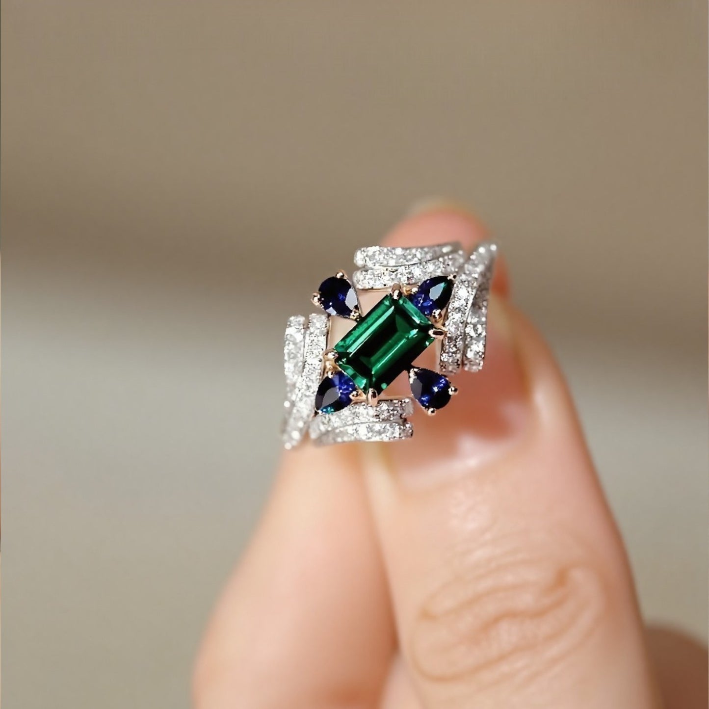 Eirisse lab emerald ring with sapphires and diamonds in white gold setting








