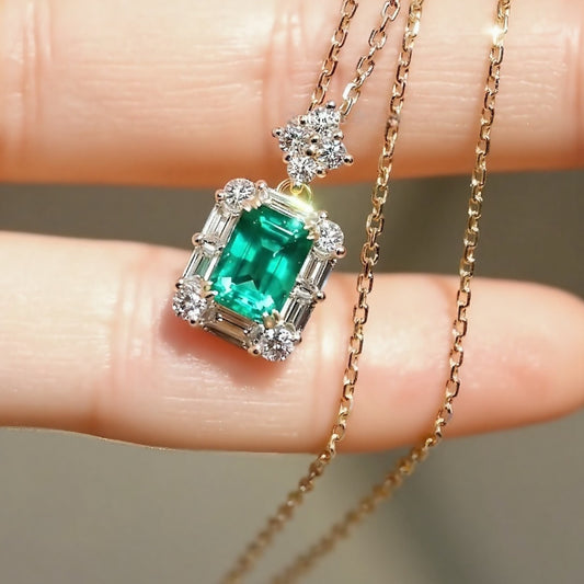 1.2ct emerald cut lab emerald pendant with diamond baguette halo on yellow gold chain








