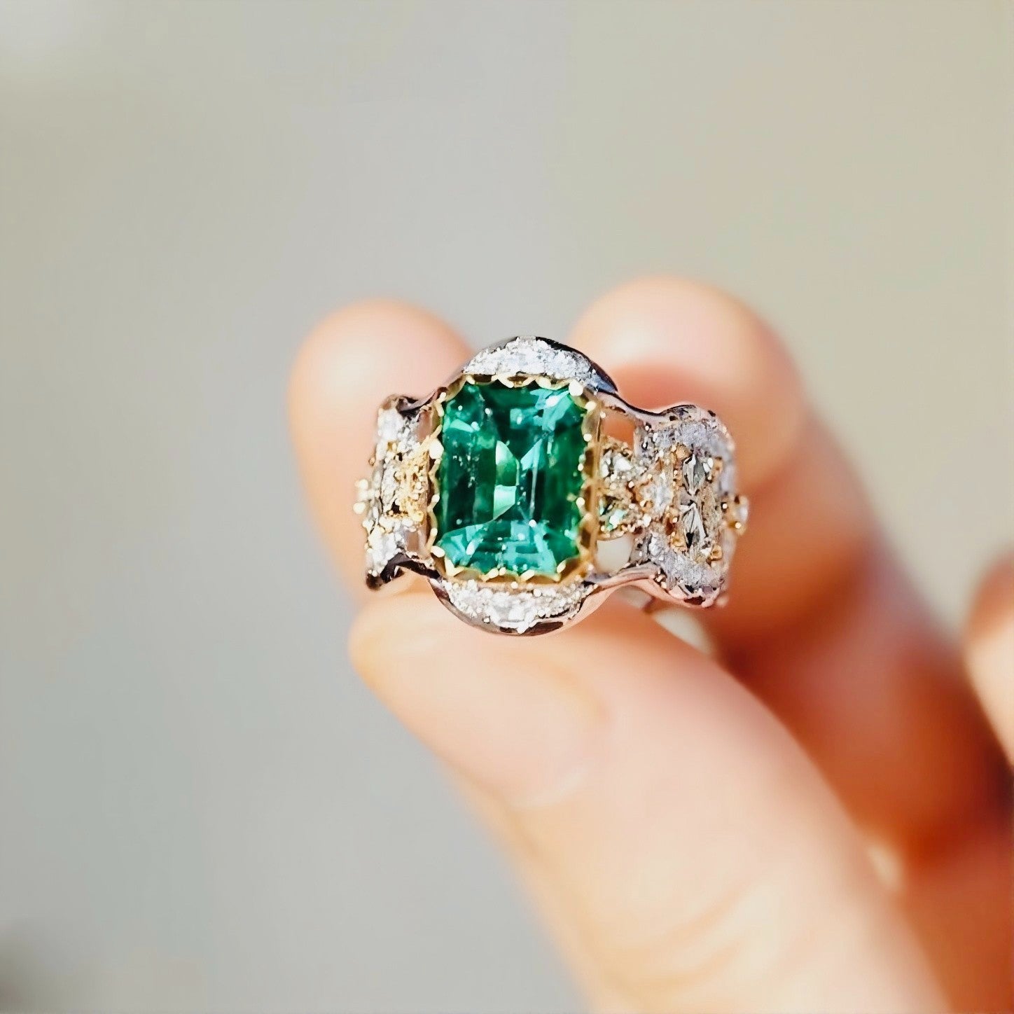 Two-tone filigree ring with 2ct lab emerald and diamond accents in ornate crown setting








