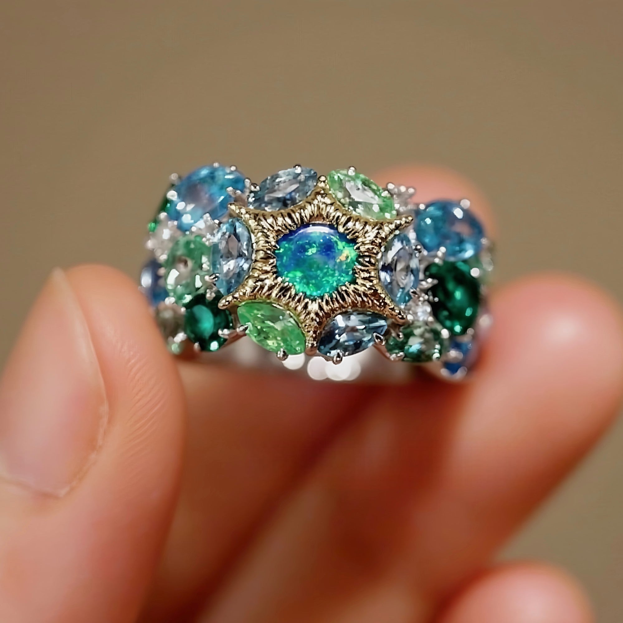 Serastra ring with doublet opal, tsavorite, and aquamarine in starburst cluster design