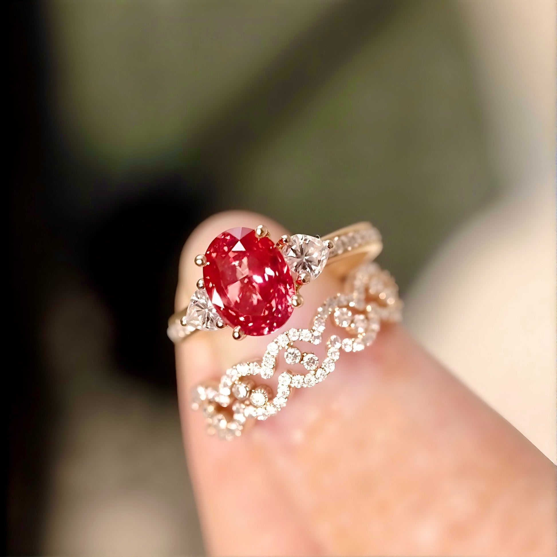 Three-piece padparadscha sapphire and diamond ring set with yellow gold bands and heart-cut accents
