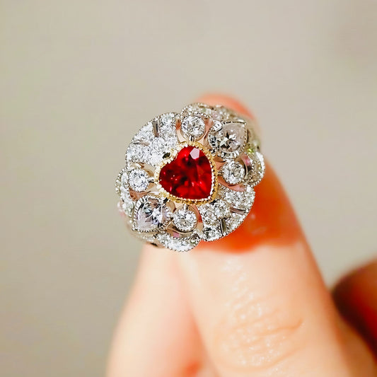 White gold ring with heart-shaped lab ruby and diamond halo in a vintage-inspired design

