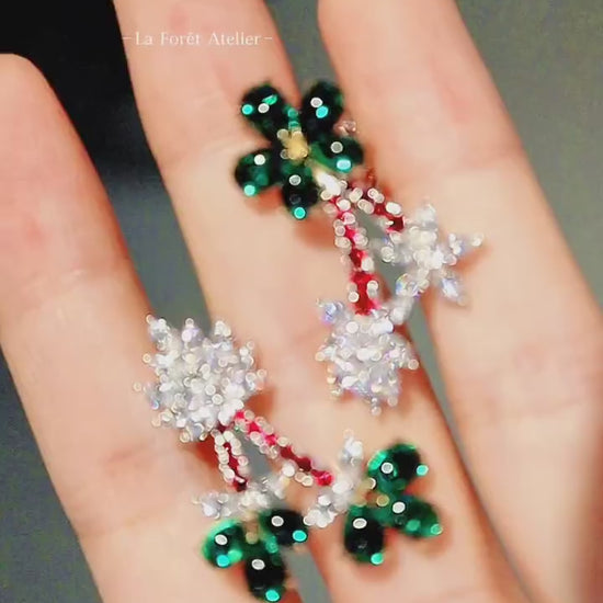 Statement flower earrings with green emerald petals and red accents









