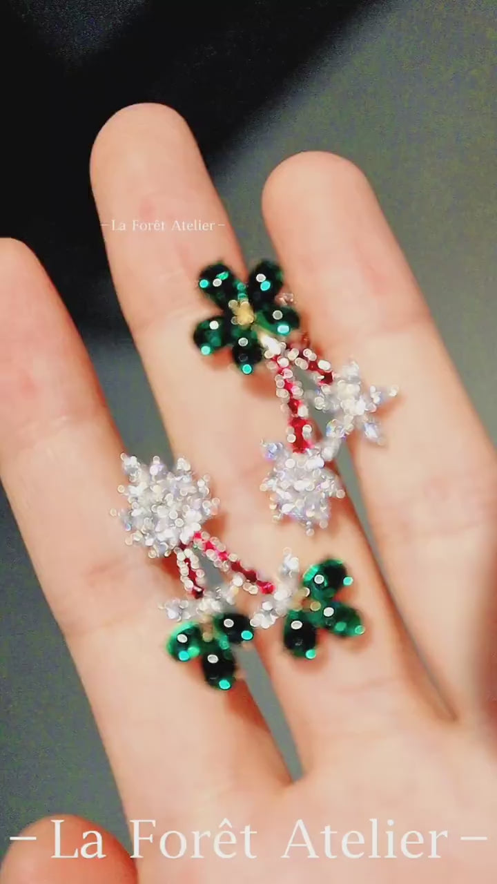 Statement flower earrings with green emerald petals and red accents








