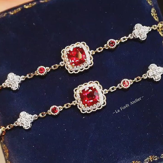 Gold bracelet featuring red lab rubies and diamond quatrefoils

