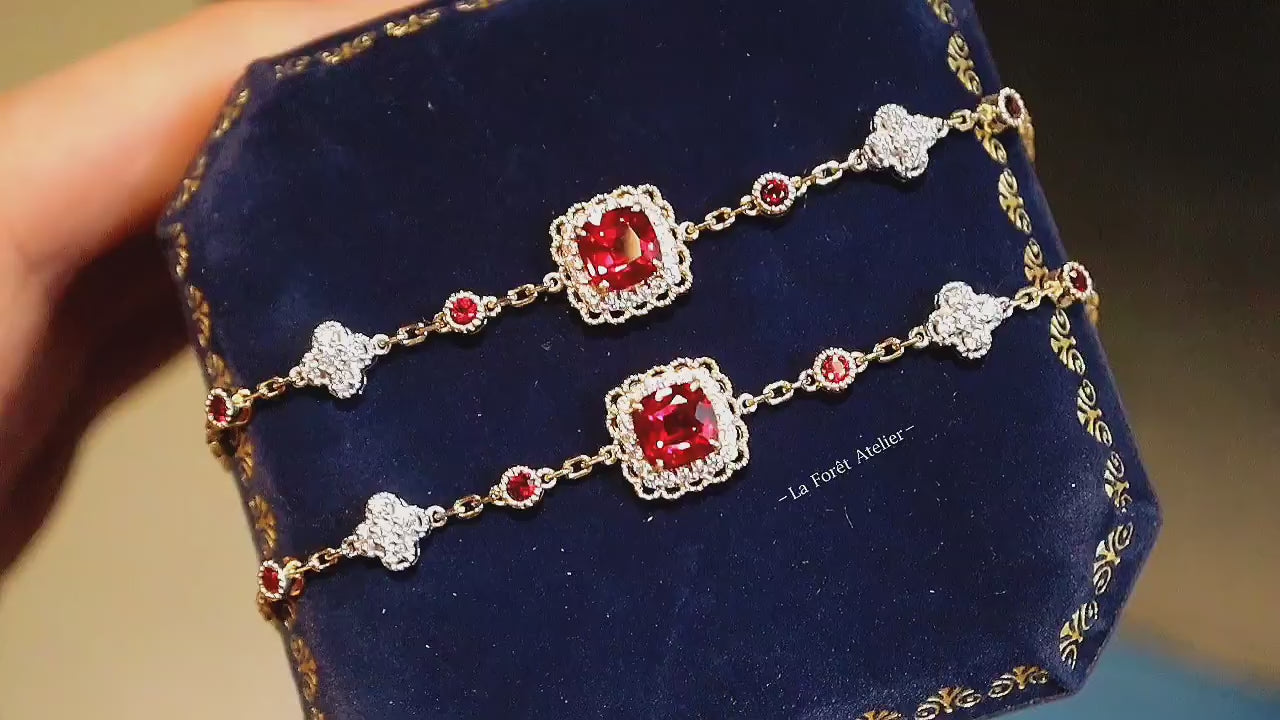 Gold bracelet featuring red lab rubies and diamond quatrefoils

