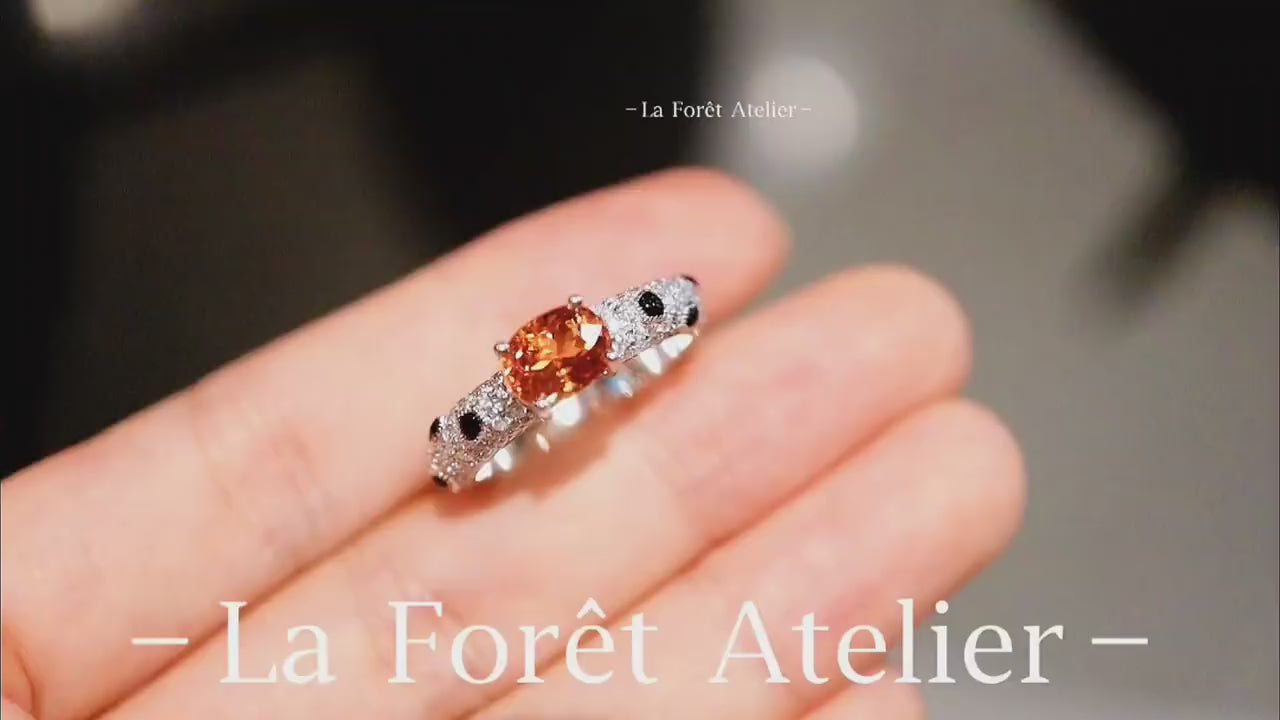 Vibrant orange garnet ring featuring black and white accents








