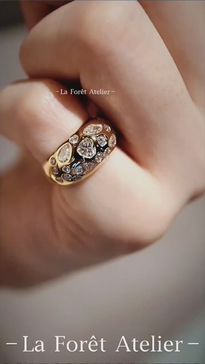 Close-up of Celeste gold dome ring with pear and marquise diamonds