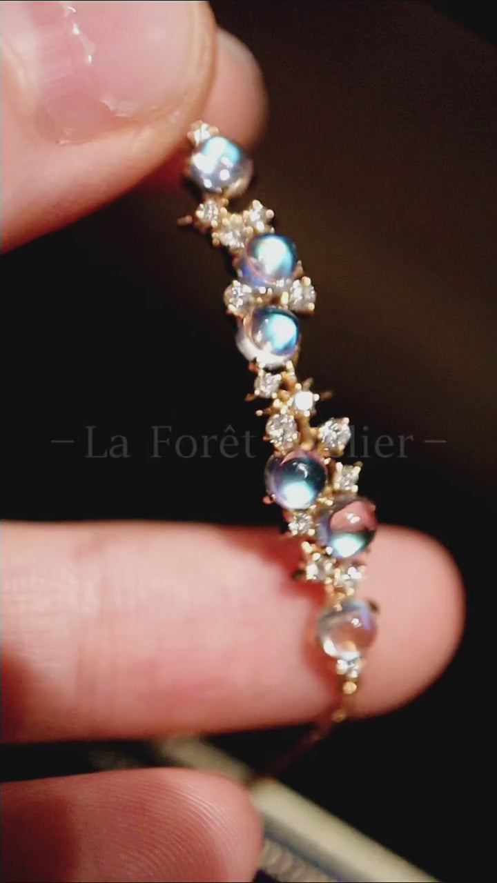 Helisse bracelet featuring glowing blue moonstones and diamond accents in gold setting