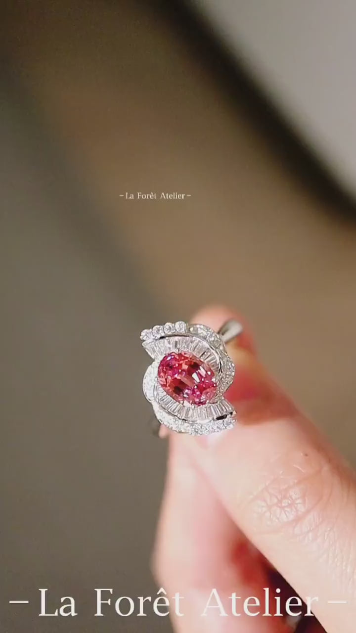 Elegant crescent diamond halo ring featuring oval lab pink-orange sapphire