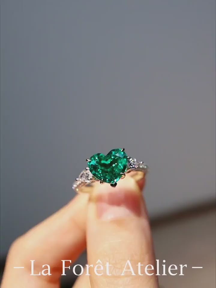 White gold ring with heart-shaped 2.5ct lab-grown emerald and lab diamond accents








