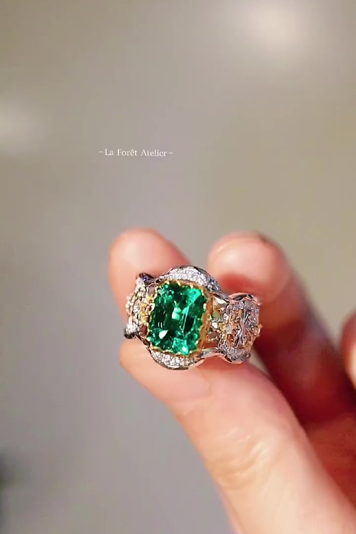 Two-tone filigree ring with 2ct lab emerald and diamond accents in ornate crown setting
