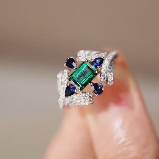 Eirisse lab emerald ring with sapphires and diamonds in white gold setting








