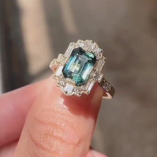 Vintage teal sapphire ring with lab-grown diamond halo in gold setting








