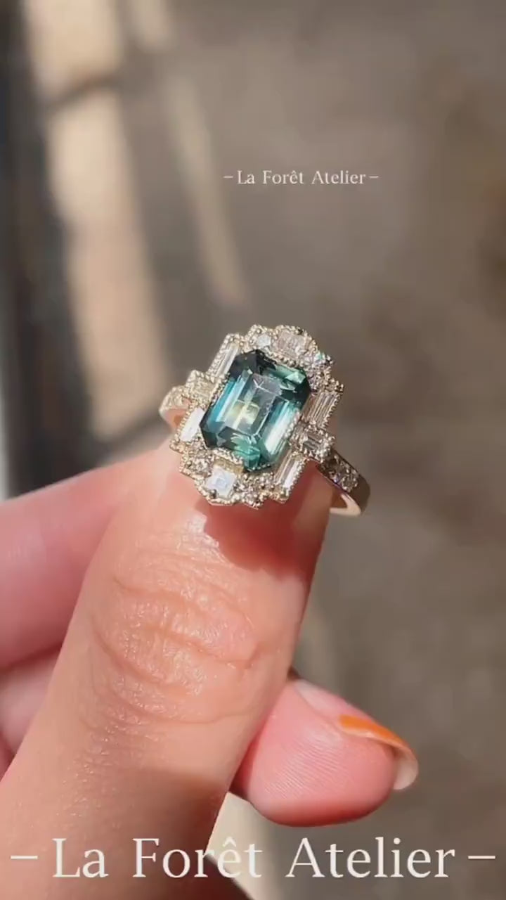 Vintage teal sapphire ring with lab-grown diamond halo in gold setting








