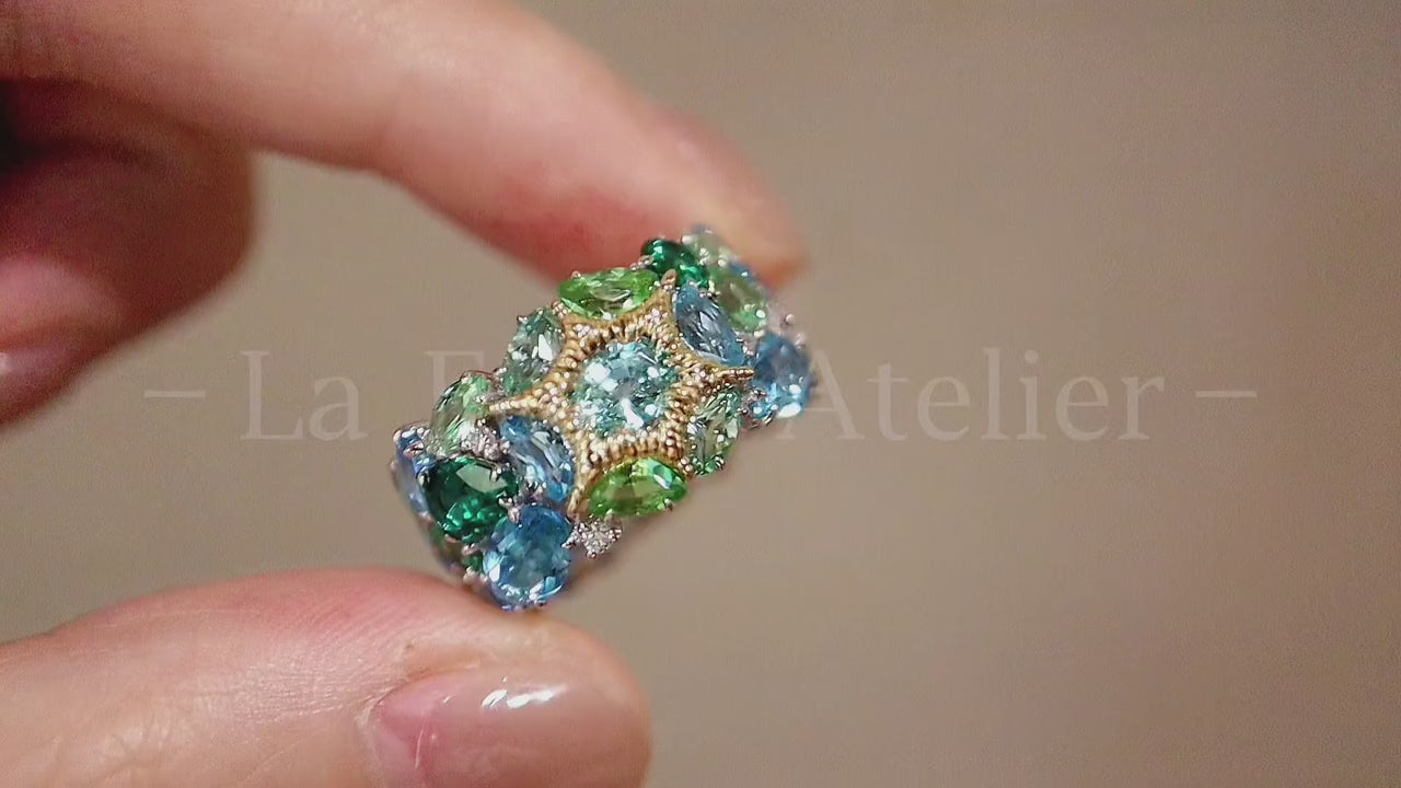 Neravelle ring with tourmaline, tsavorite, and aquamarine gemstones in starburst gold and platinum cluster setting – colorful cocktail band ring design


