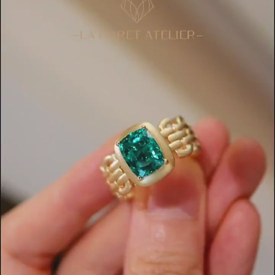 Avarelle ring featuring 3ct cushion cut lab grown emerald in matte gold bezel and linked gold band








