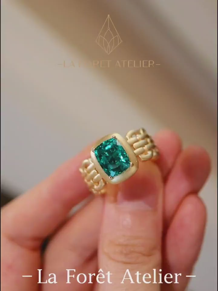 Avarelle ring featuring 3ct cushion cut lab grown emerald in matte gold bezel and linked gold band








