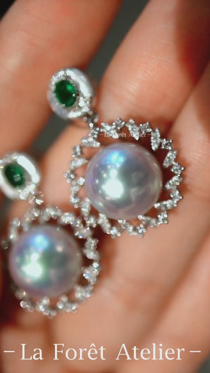 Close-up of Amaris pearl and emerald drop earrings with diamonds
