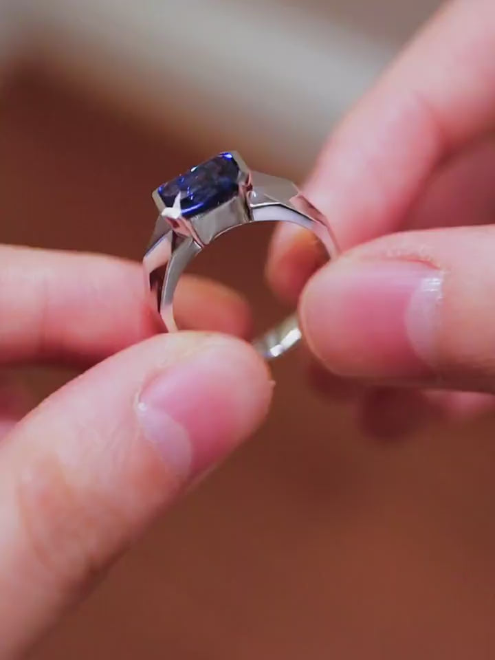 Modern bezel-set ring with 2ct emerald-cut lab-grown sapphire in silver band








