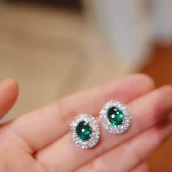 Pair of oval lab emerald stud earrings with double halo setting


1/2








