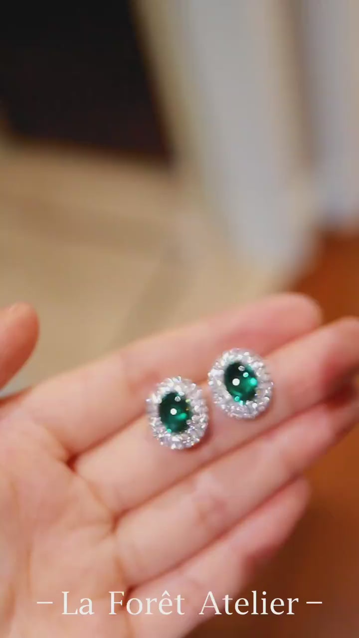 Pair of oval lab emerald stud earrings with double halo setting


1/2








