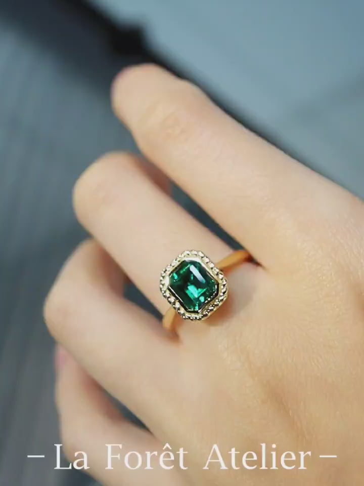 Belline ring with emerald-cut lab-grown emerald and diamond halo in gold setting








